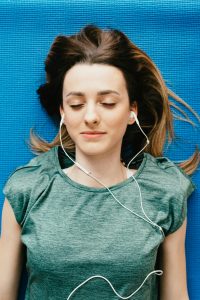 A picture of someone wearing headphones with their eyes closed, looking calm