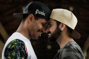 Two people smiling and holding their heads together touching noses