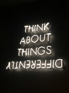 A sign saying 'think about things differently' with the word 'differently' shown upside down
